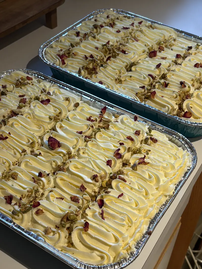 Two catering trays of dessert with pistachio and rose petals